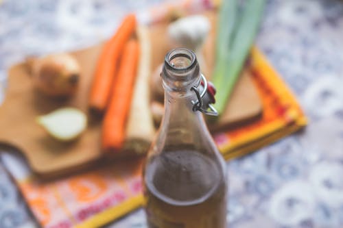 Clear Glass Bottle With Brown Liquid in Selective Focus Photography