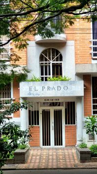 Elegant entrance to El Prado apartment in Medellín, featuring distinct architecture and greenery.