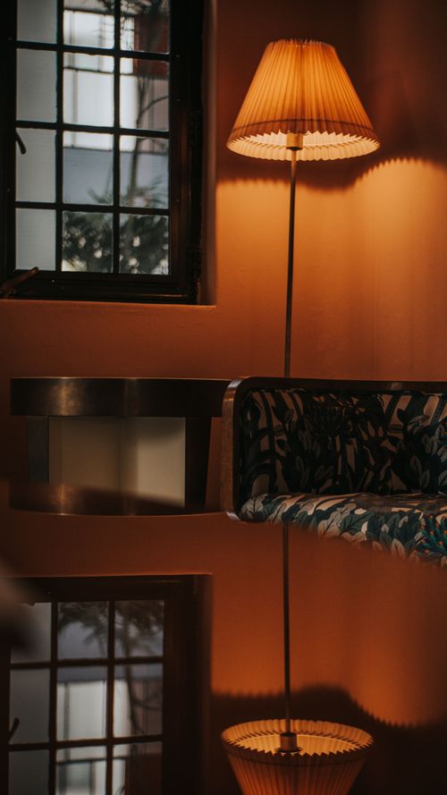 Free Warm interior with a lamp reflected on a surface, emphasizing cozy ambiance. Stock Photo
