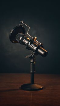 Close-up of a professional microphone with pop filter on stand, ideal for podcasting and recording.
