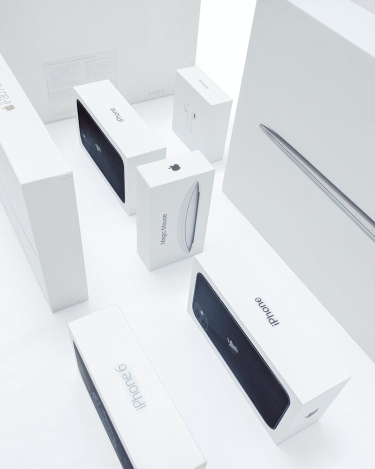 Boxes Of Various Apple Products On A White Surface