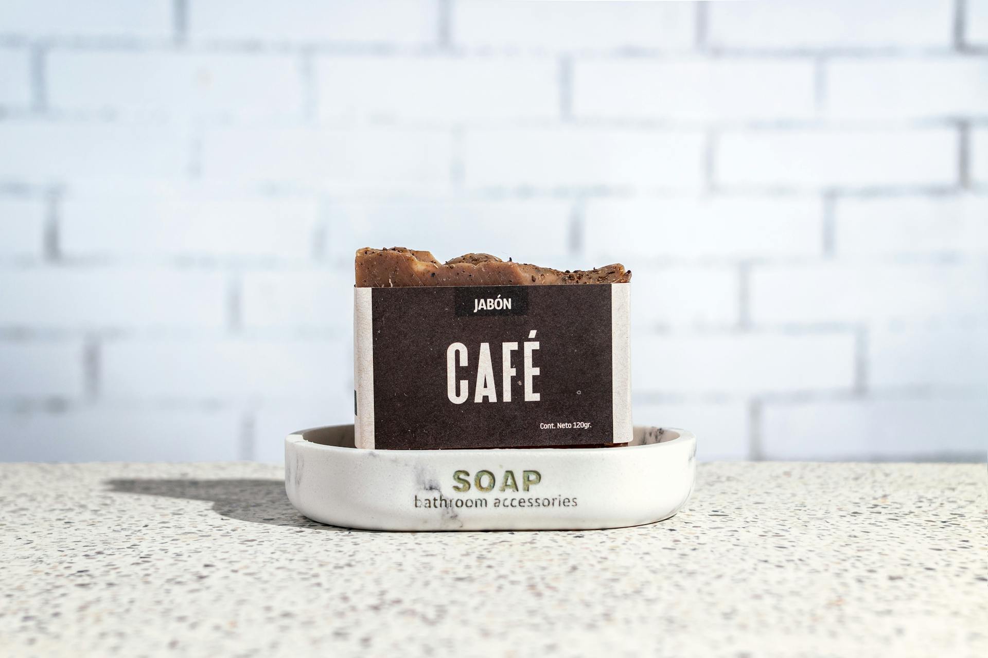 Close-up of coffee scented soap bar on a tray against a brick wall.