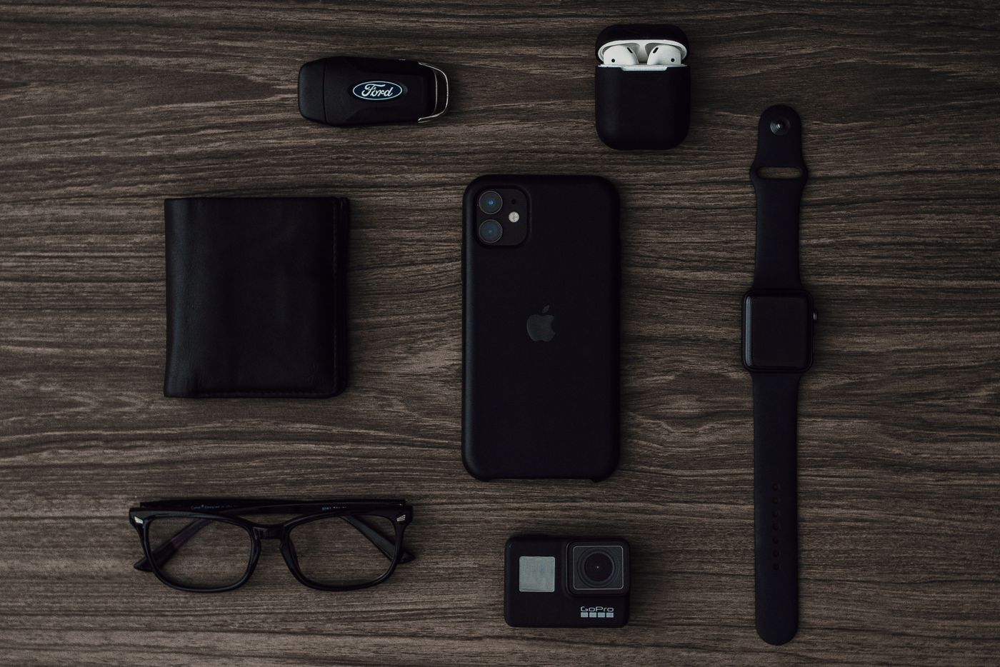 Everyday carry gadgets laid out on a wooden surface