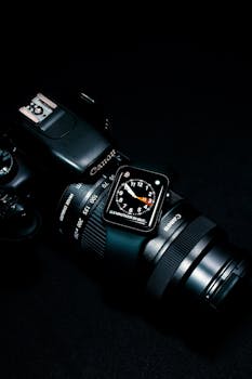 A sleek digital watch displayed on a DSLR Canon camera against a dark background. Perfect for tech enthusiasts.