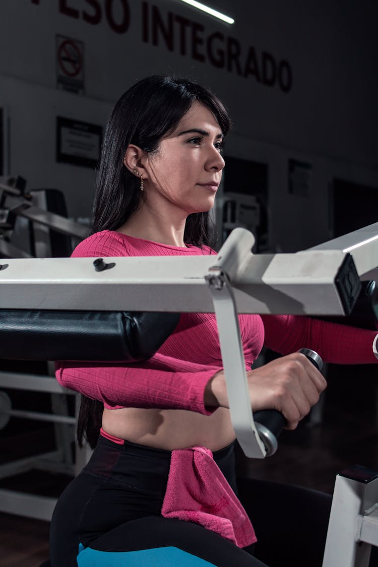 A Woman In Pink Long Sleeve Shirt Working Out In The Gym