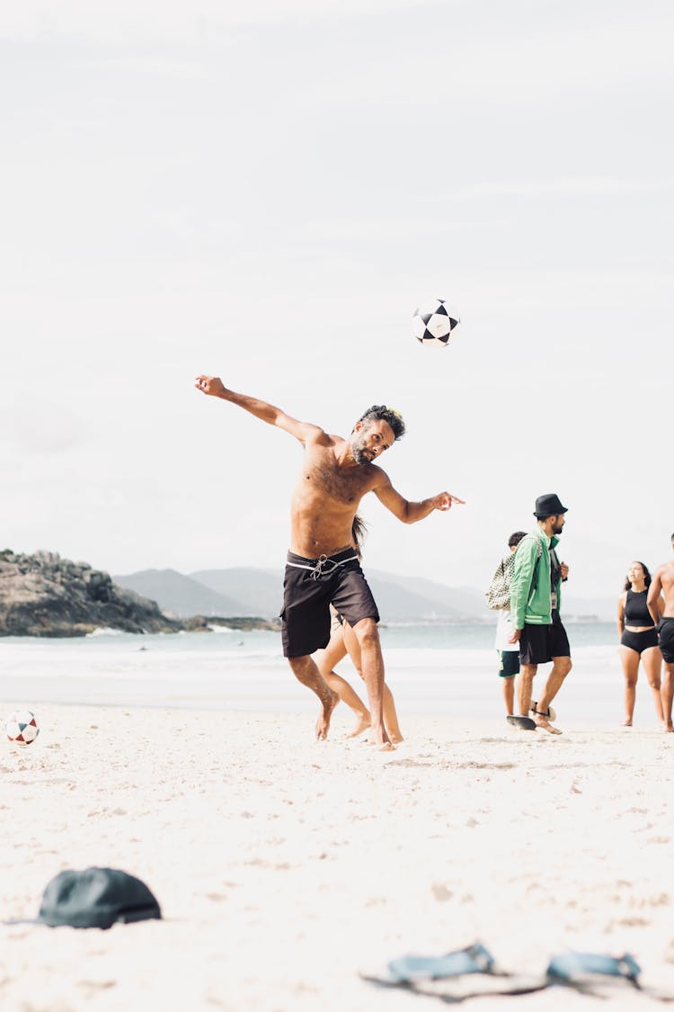 Man Playing Football On Beach