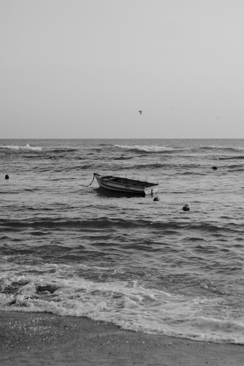 Grayscale Photo of a Boat in the Sea