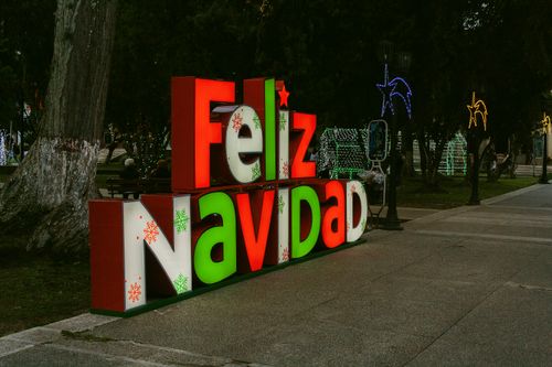 Free Colorful Feliz Navidad sign with festive lights in Mérida, Venezuela park setting. Stock Photo