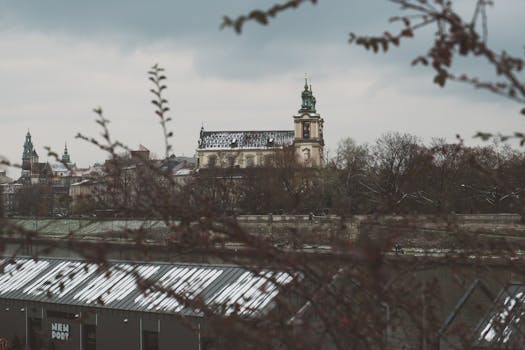 View of a historic church in Kraków, Poland, with wintry trees in the foreground.