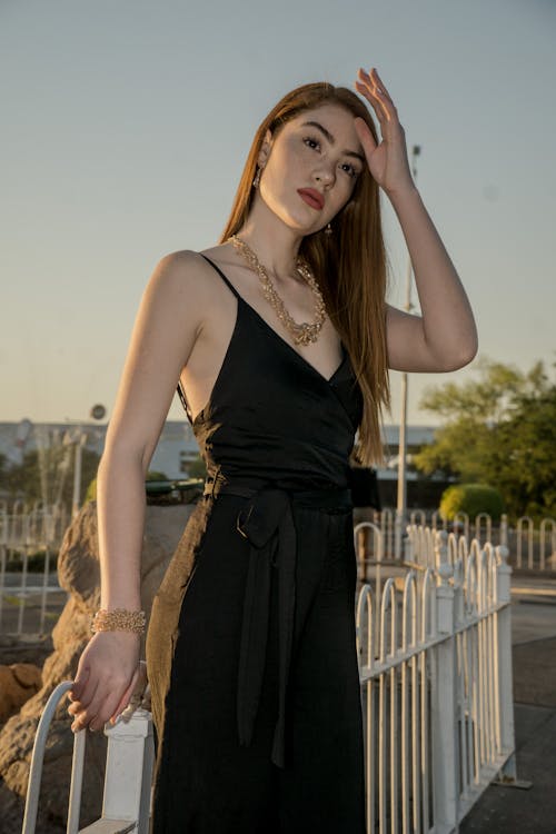 Woman Standing Near White Metal Fence