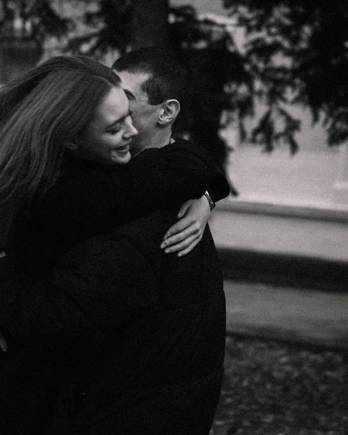 Free Black and white photo of a couple embracing warmly in an outdoor setting. Stock Photo
