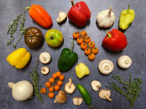Vibrant array of fresh vegetables like peppers, tomatoes, and mushrooms in flatlay style.