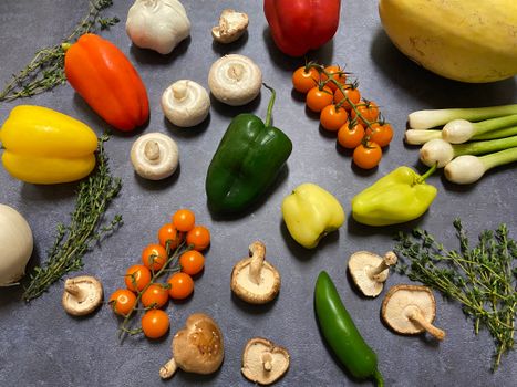 Discover a vibrant collection of fresh vegetables and mushrooms arranged on a dark background, perfect for cooking inspiration.