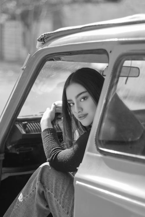 Black and White Photo of Woman Inside the Car