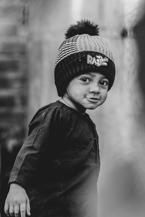 Grayscale Photo of Boy Wearing Knit Cap and Black Long Sleeve Shirt