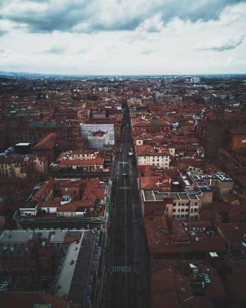 Free Stunning aerial view of a city with historic rooftops and scenic skyline under a dramatic sky. Stock Photo