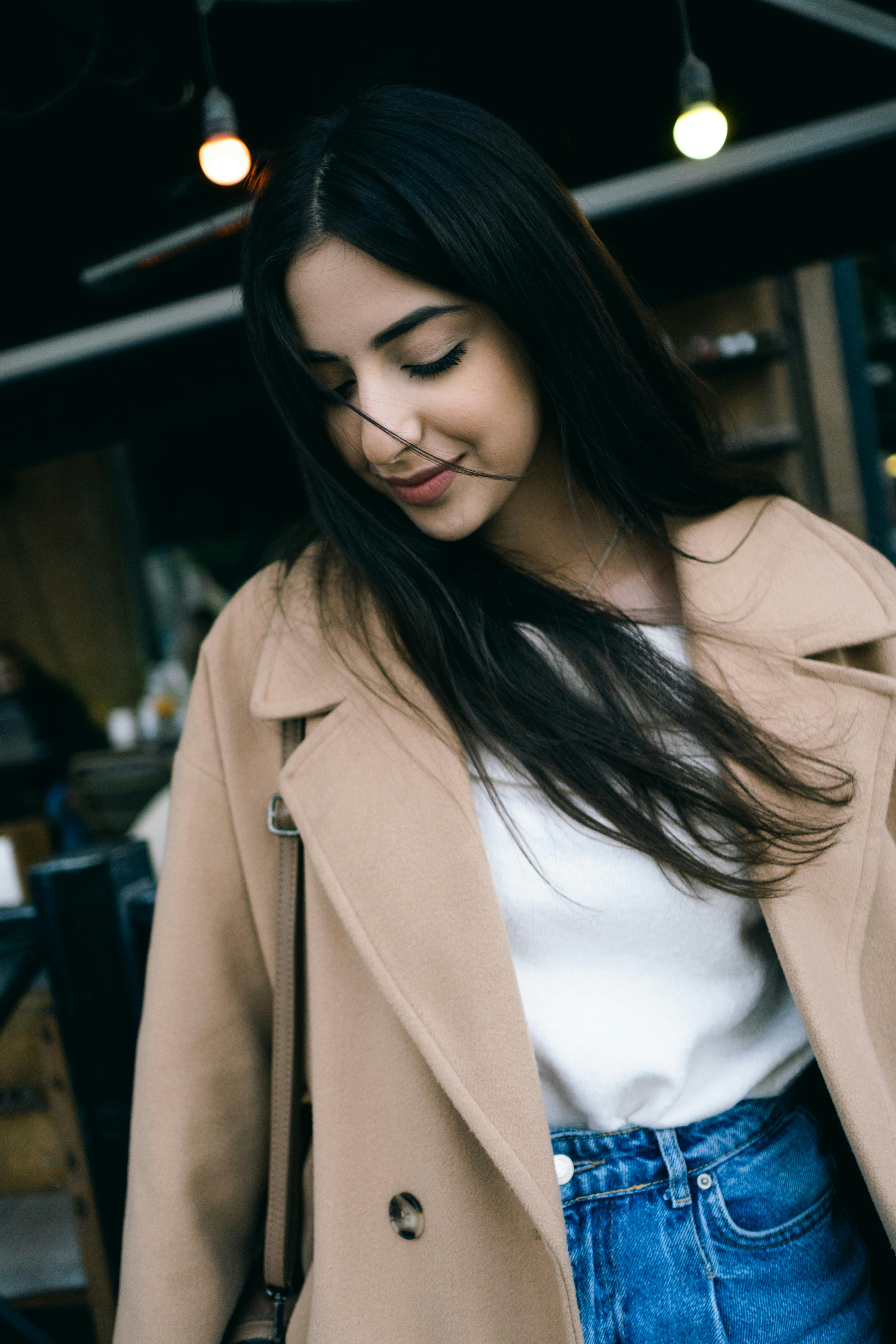 young woman smiling in beige coat