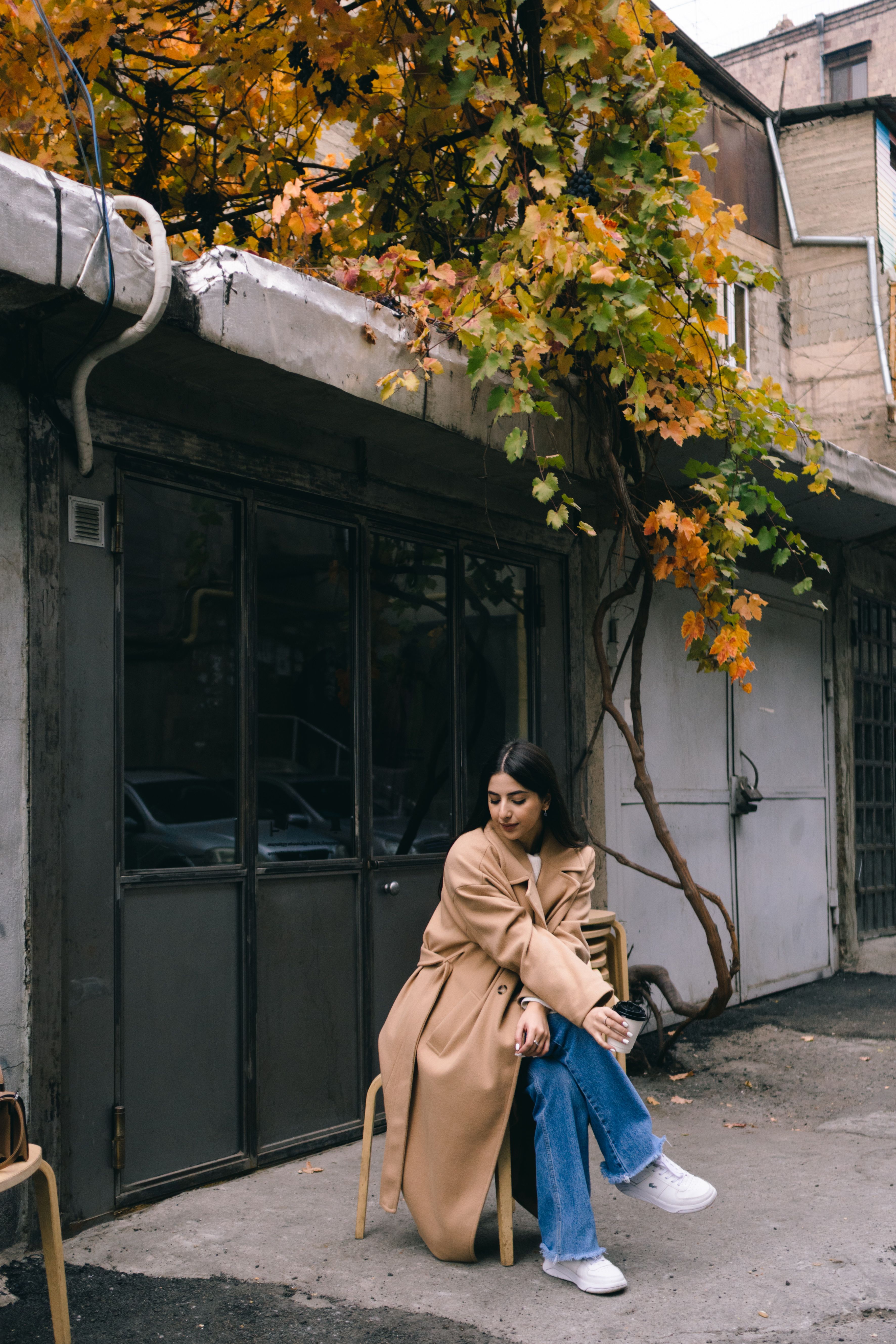 Beautiful Woman in Brown Coat Sitting on a Chair on the Street · Free ...