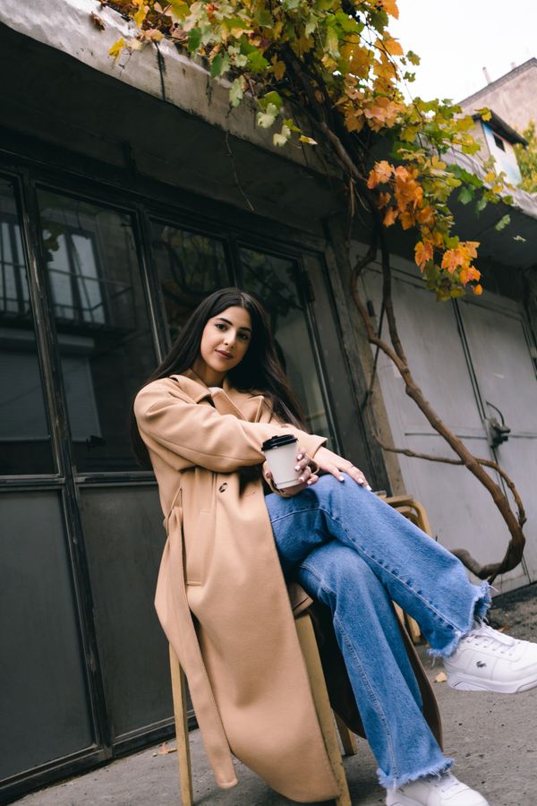 Woman in earth-tone coat and jeans