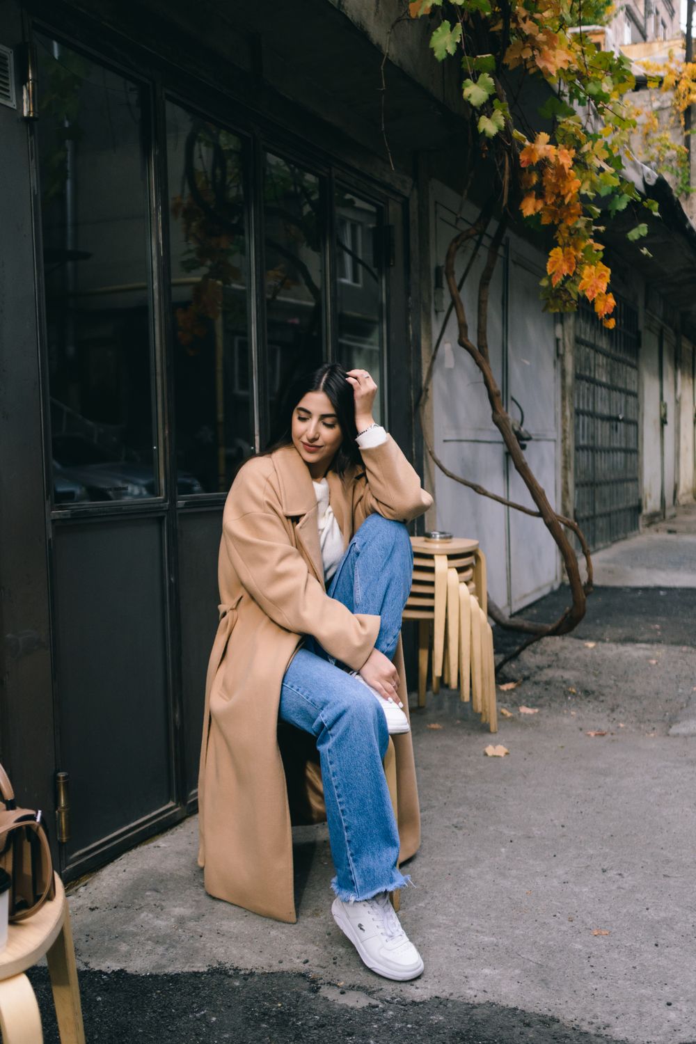 Woman in dark jeans and camel wool coat