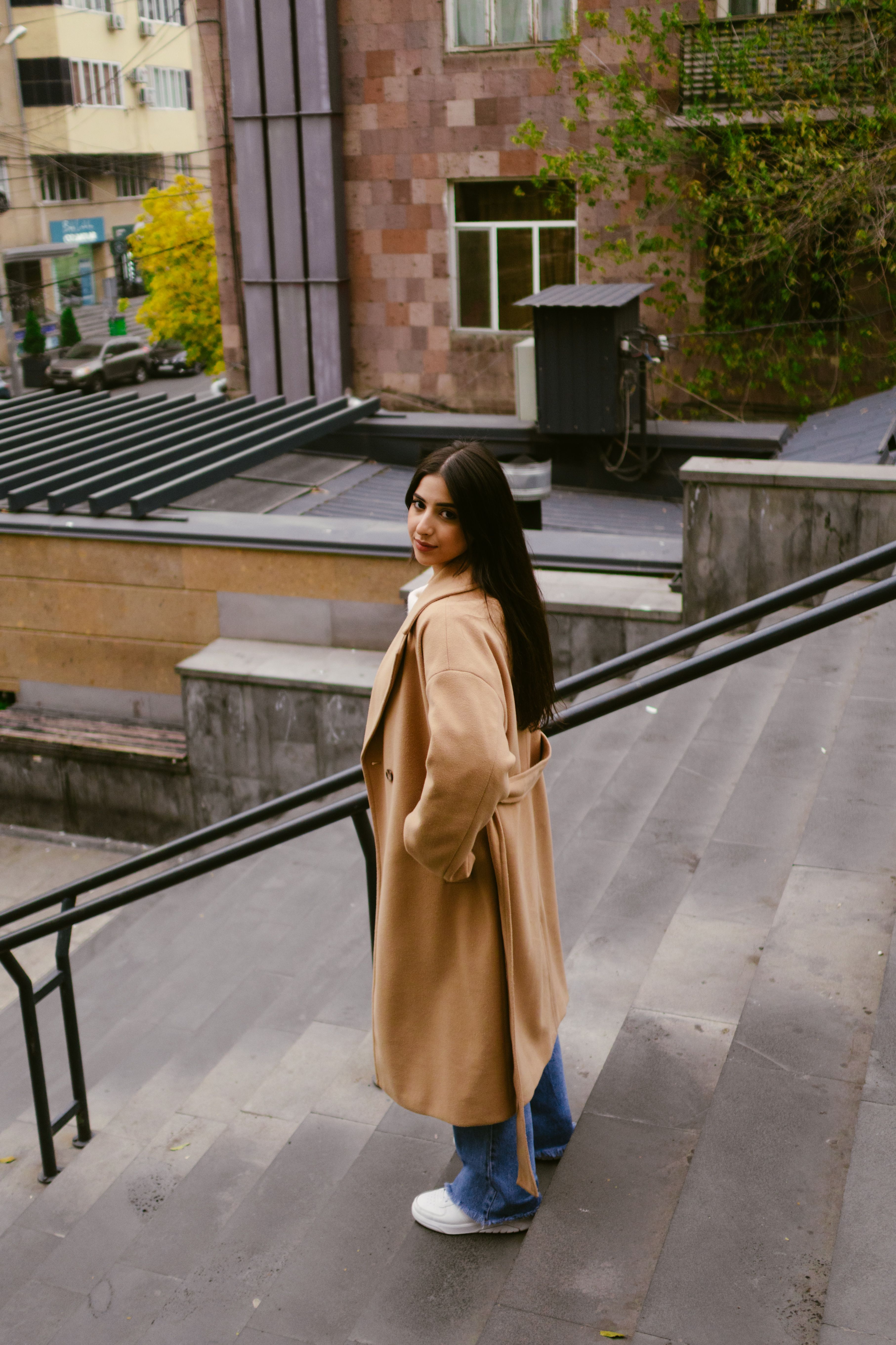 Woman in trench coat on a rainy day street