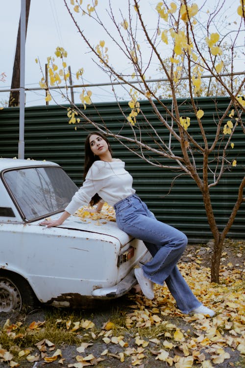 Stylish Young Woman leaning in an Abandoned Car 