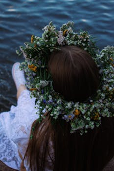 Rear view of a woman in a flower crown sitting by the water in Minsk.