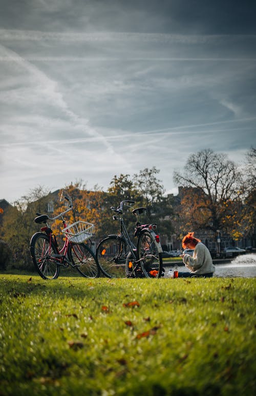 People with Bikes Sitting on Grass on Field