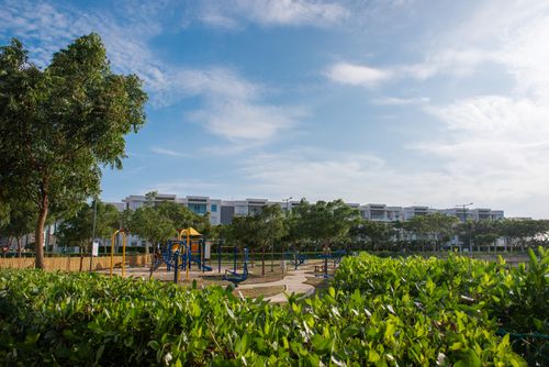 Free Vibrant playground surrounded by green foliage and modern architecture under a clear summer sky. Stock Photo