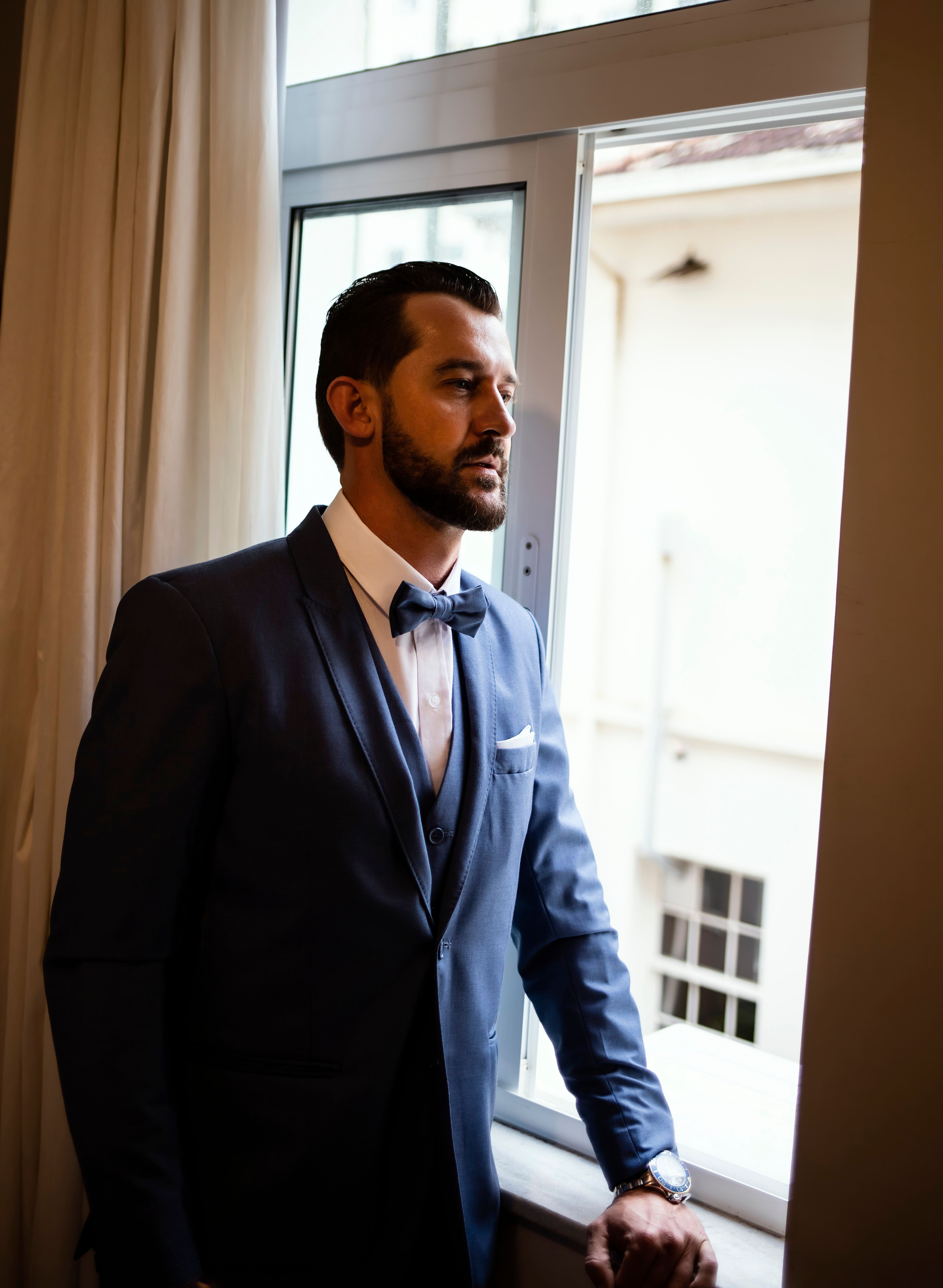 Man in a Suit Standing Near Window · Free Stock Photo