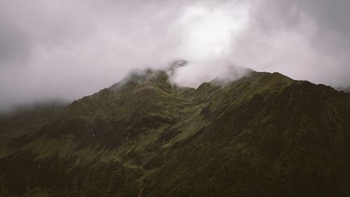 Free A breathtaking mist-covered mountain peak surrounded by thick clouds. Stock Photo