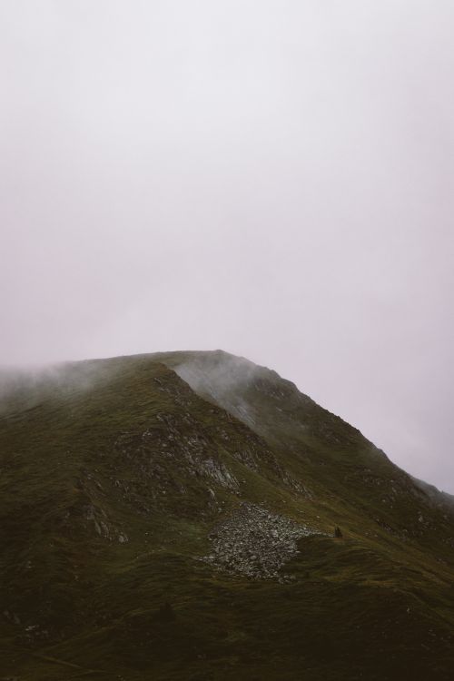 Free Serenity of a mountain peak enveloped in mist, capturing the essence of a foggy outdoors landscape. Stock Photo