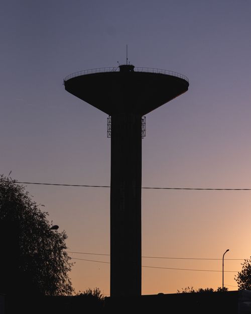 Free A silhouetted radio tower against a vibrant sunset sky, creating a striking contrast. Stock Photo