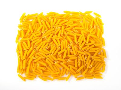 Uncooked penne pasta on a white background — photo by Engin Akyurt on Pexels