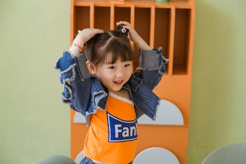 Girl in Blue Denim Jacket and Orange Shirt
