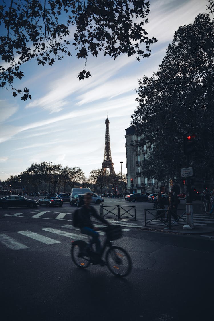 Man Cycling On Street With Eiffel Tower In Background