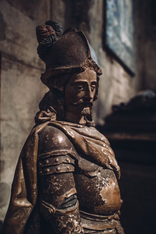 Free A detailed stone statue of a medieval knight inside a museum, highlighting historical artistry. Stock Photo