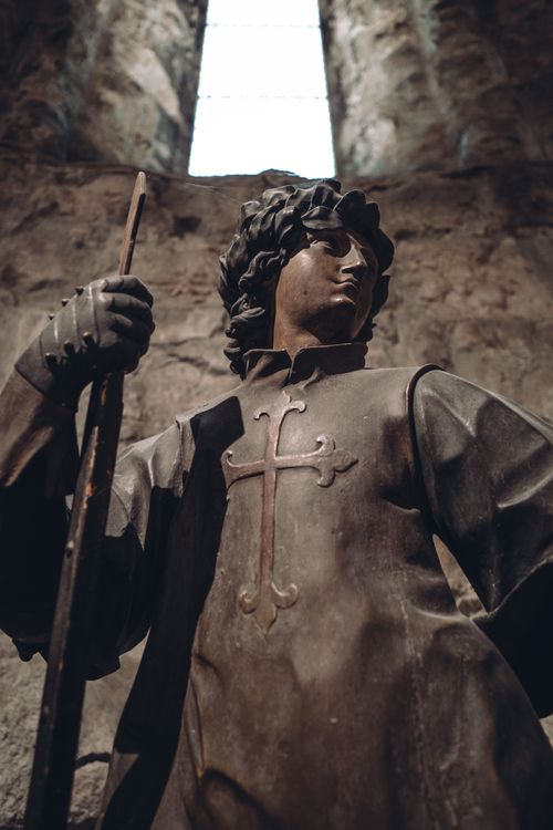 Free Dramatic low angle view of a medieval knight statue inside a stone castle. Stock Photo