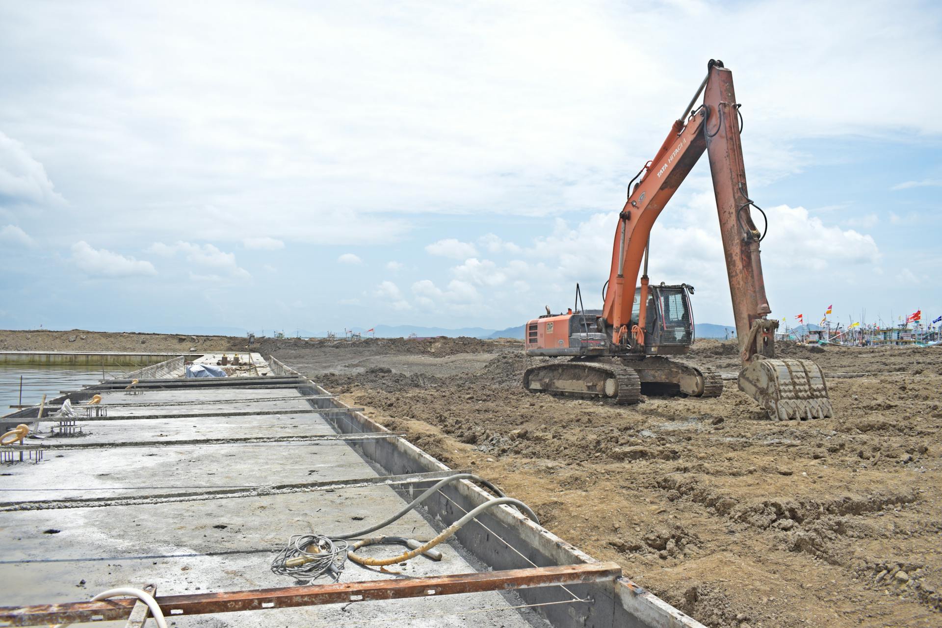 A large excavator machine working at an open construction site during the day.