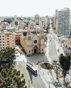 Explore an aerial view of Curitiba, showcasing the iconic Curitiba Cathedral amidst the vibrant cityscape.