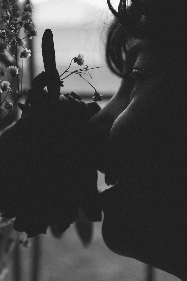 Black And White Photo Of A Girl Smelling A Flower