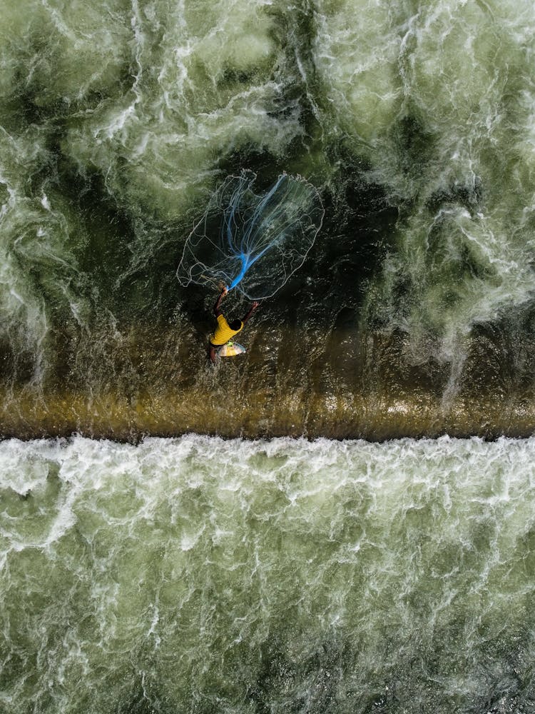 Fisherman With Net In Water