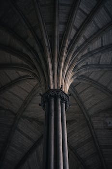 Intricate Gothic column and ceiling in a cathedral, showcasing exquisite architectural design.