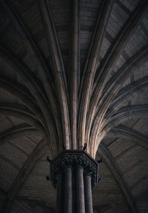 Free A striking view of a Gothic cathedral's vaulted ceiling with intricate arches and columns. Stock Photo