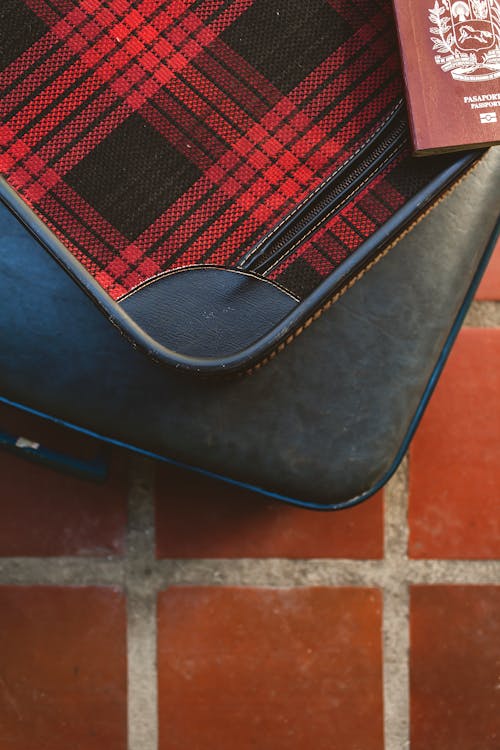 Suitcases and Passport Lying on Tiles