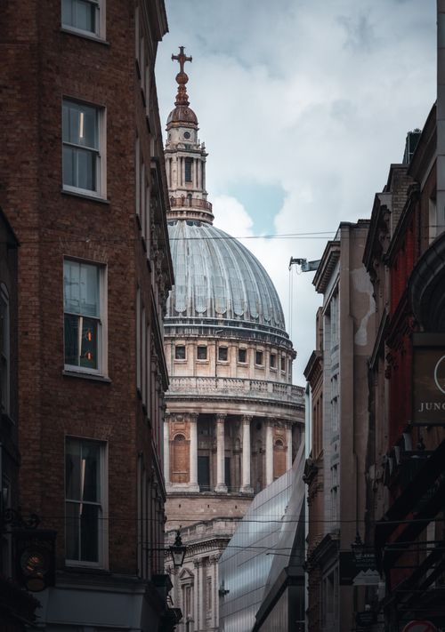Free St. Paul's Cathedral framed between city buildings in London, UK. Stock Photo