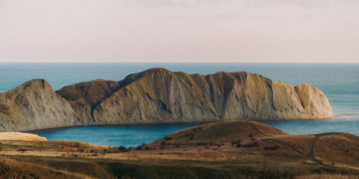 Breathtaking view of cliffs overlooking the ocean with clear, calm waters and a serene atmosphere.
