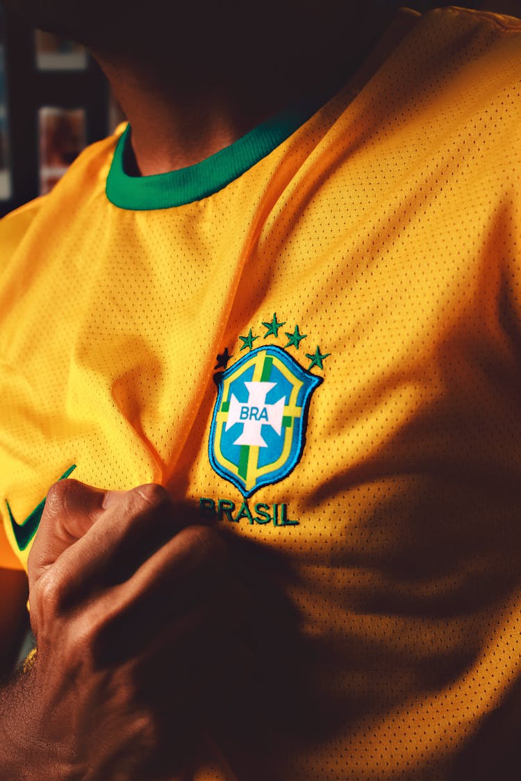 Hand Holding Brazil Fotobal T-shirt Near Emblem