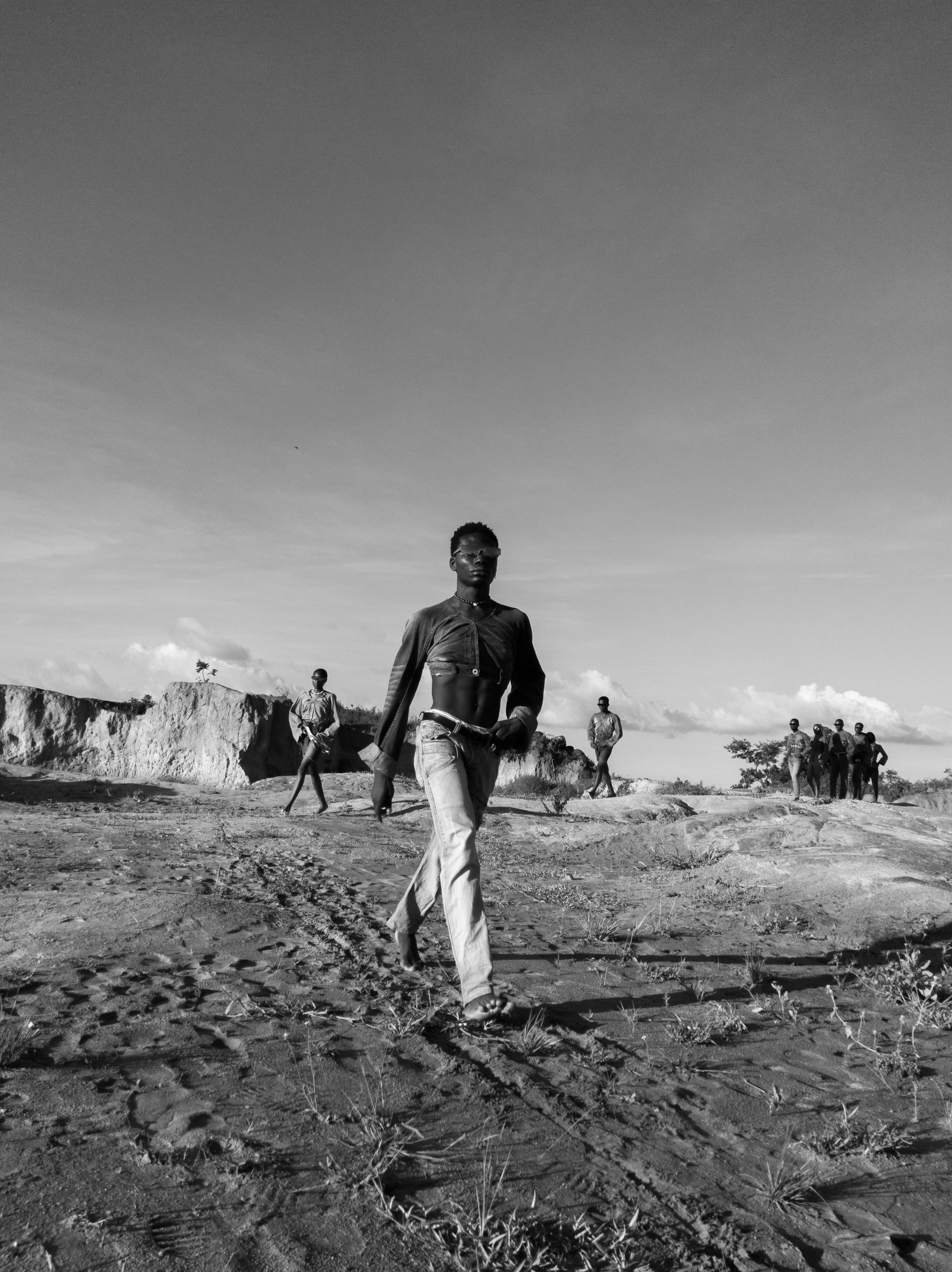 man walking on wasteland in black and white