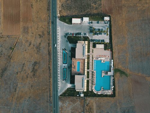 Free Aerial shot of a resort with swimming pools surrounded by agricultural fields in Albania. Stock Photo